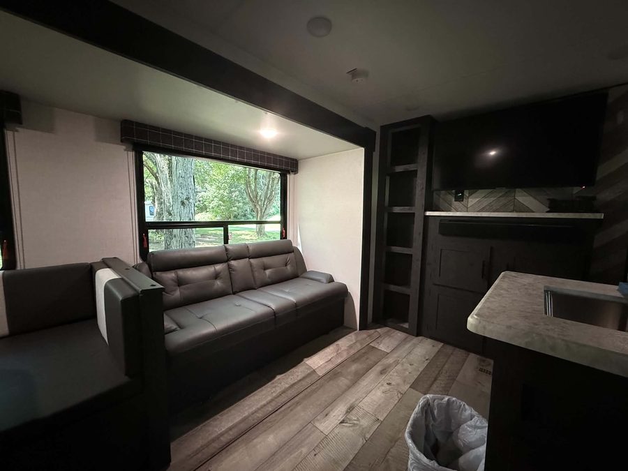 Sofa, picture window and TV in the bunkhouse RV rental living area