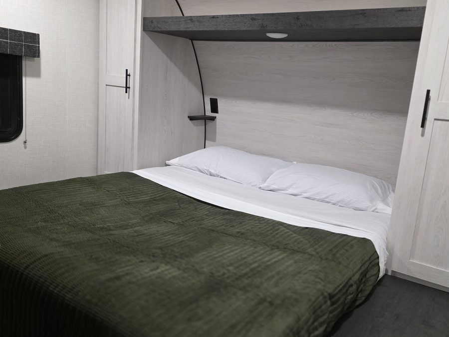 Queen bed with closets on both sides in the bunkhouse RV rental